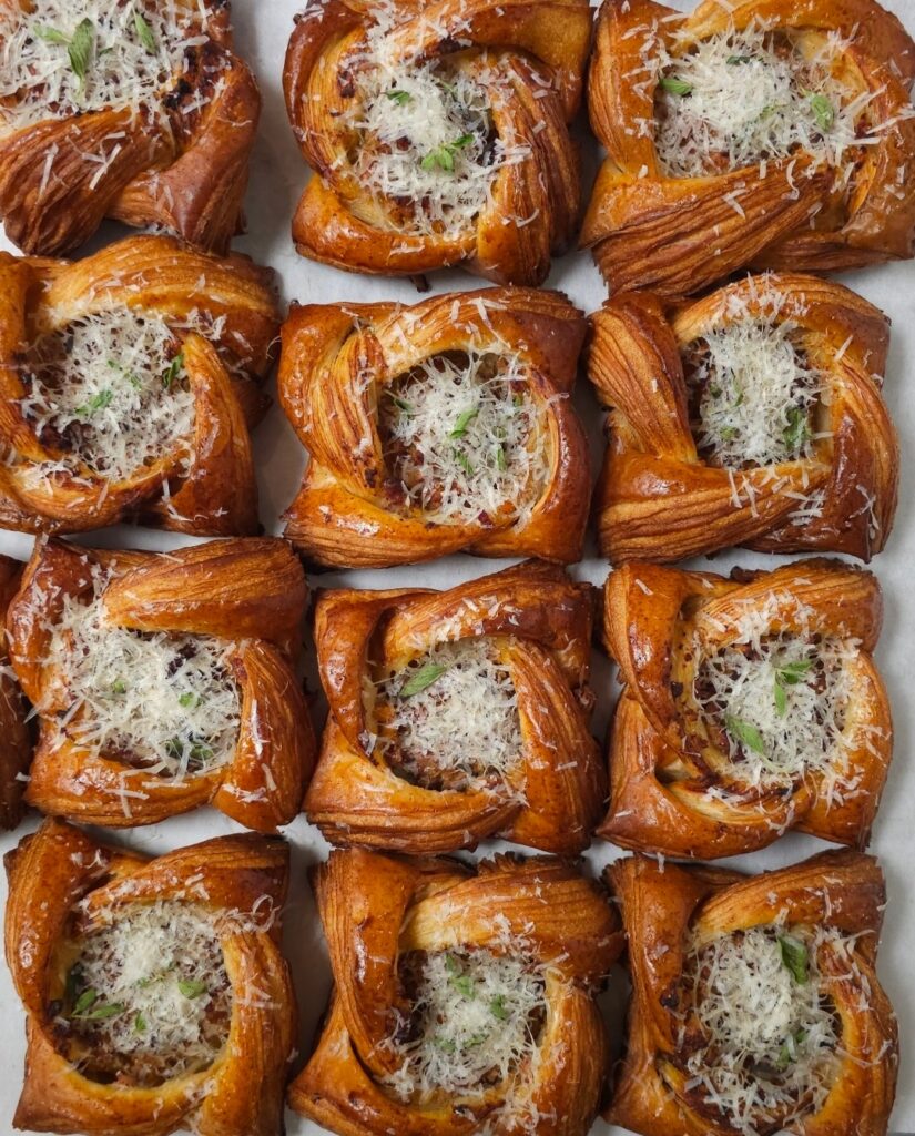 an overhead shot of rows of flaky pastries filled with meat and cheese