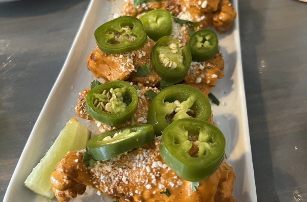 Saucy wings topped with sliced jalapeños.