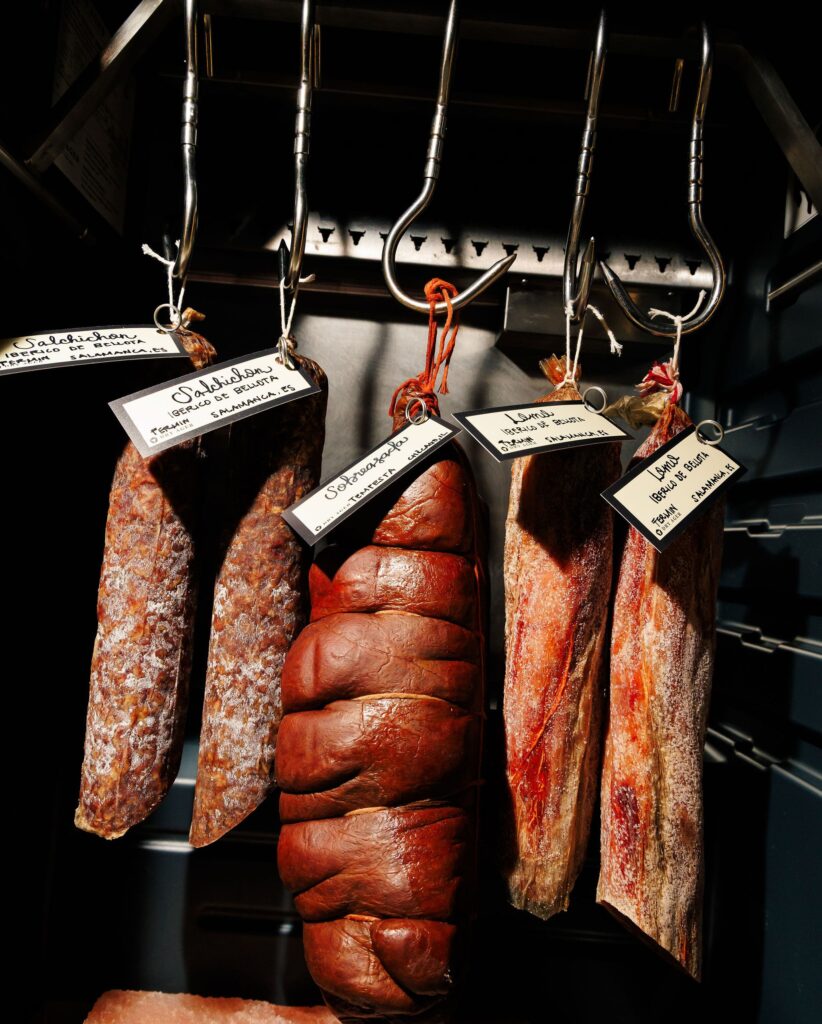 Meats hang by hooks.